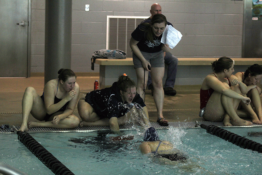Cheering for her teammate alongside freshman Anika Roy and coach Kate Dailey, junior Payton Frye signals the final lap in the 500 yard freestyle.