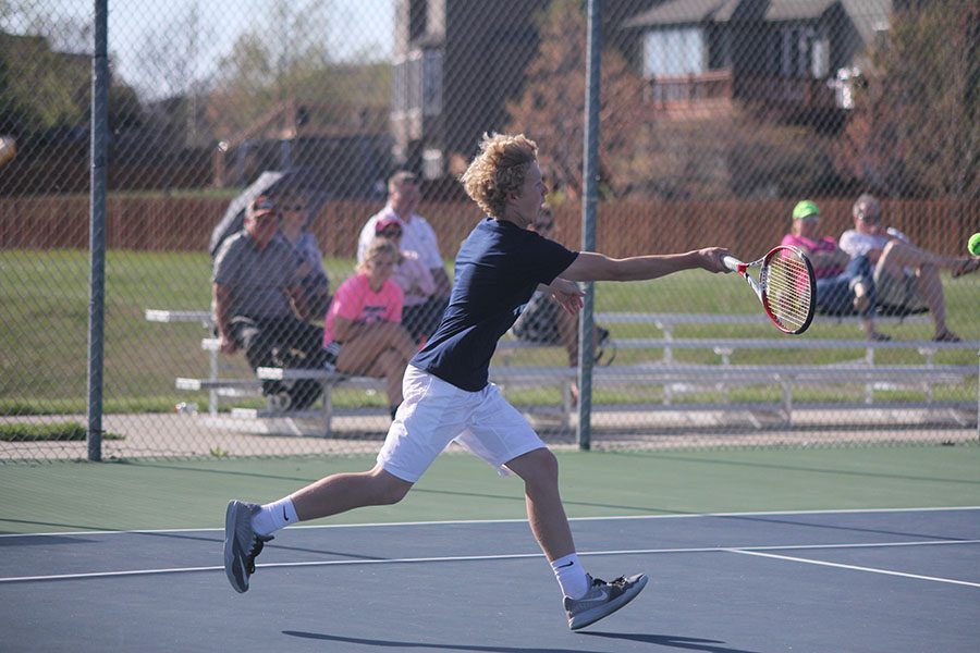 Sophomore Dante Peterson runs to hit the ball as it crosses the net