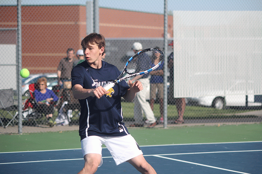Junior Alec Bergeron hits the ball during a doubles match