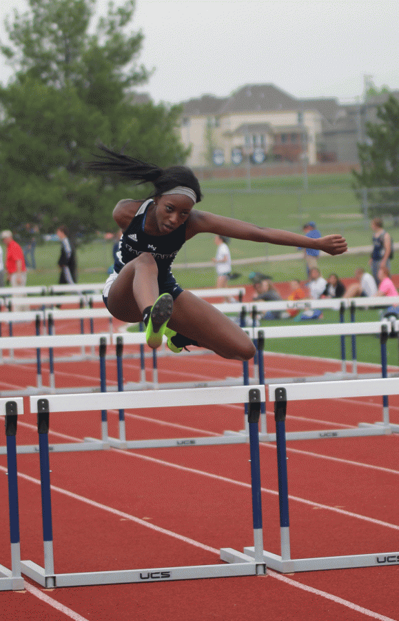 Junior Nicole Lozenja jumps over a hurdle in the girls 100 meter hurdles on Tuesday, April 19.