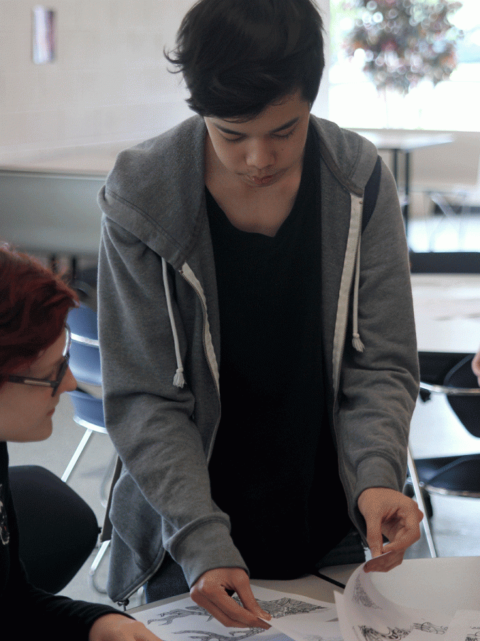 At the beginning of the event, sophomore Simon Vongxay selects his coloring sheets.