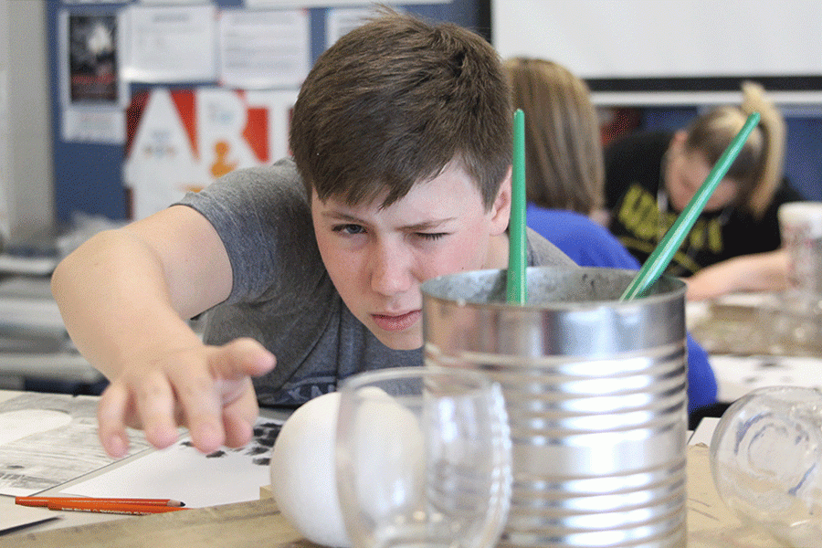 Adjusting the composition for his still-life during Drawing on Wednesday, April 28, freshman Jack Jaworski prepares to use charcoal and a blending stump to make his drawing of staged spheres and cans look three-dimensional. “The most challenging part of the project was the charcoal because it was hard to match the right values and to get rid of all the directional marks,” Jaworski said. “It is helping me to develop value more and to make my drawings more realistic. Up until now, they have all been cartoony, so now my drawings are able to look like an actual photograph.”