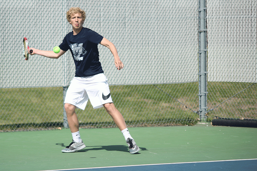 With the ball advancing towards him, sophomore Dante Peterson lifts his racket to hit the ball.