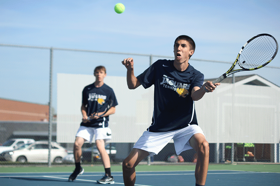 In a doubles match against St. James, junior Andrew Bock prepares to make contact with the ball on Thursday, April 14. Boys team went 10-2 to tie with St. James for first place.