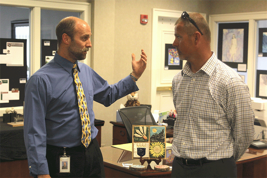 During the first day of the art show on Monday, April 25, art teacher Jerry Howard and athletic director Jerald VanRheen converse over the art displayed