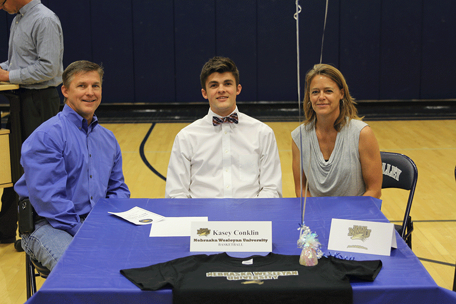 Before signing his letter of intent, at the ceremony, to play basketball at Nebraska Wesleyan University, senior Kasey Conklin smiles for the camera with his family