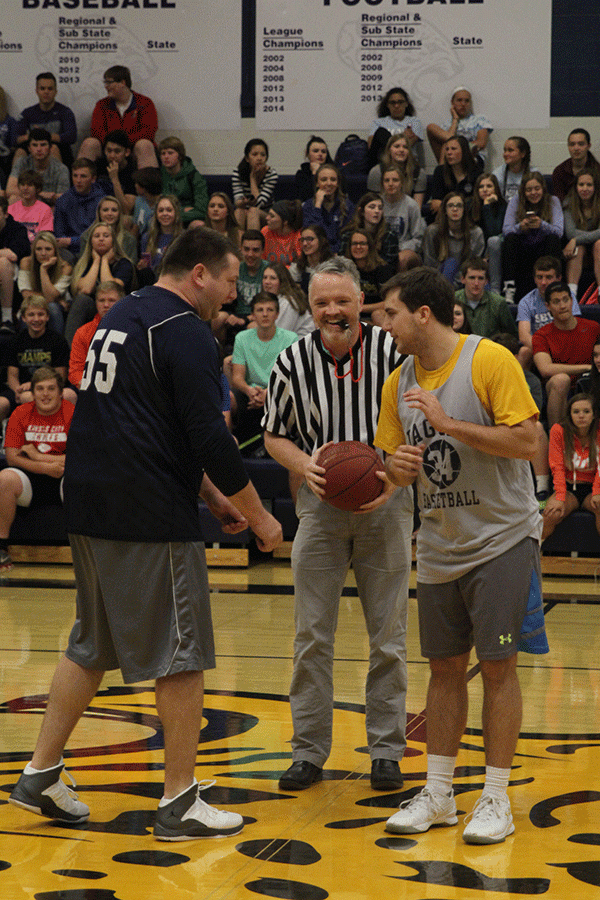 Science teacher Chad Brown prepares to toss the ball up between math teacher Alex Houlton and senior Logan Koch