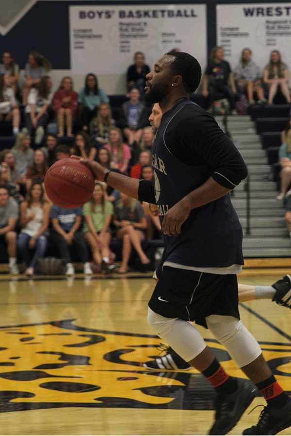 Paraprofessional Geff White dribbles the ball down the court. 