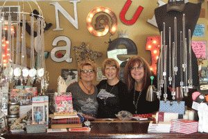 At the Junque Drawer boutique on Saturday, April 30, employees Sandy Keating, Ami Levin, and owner Jane Hosey Stern stand behind the front register.