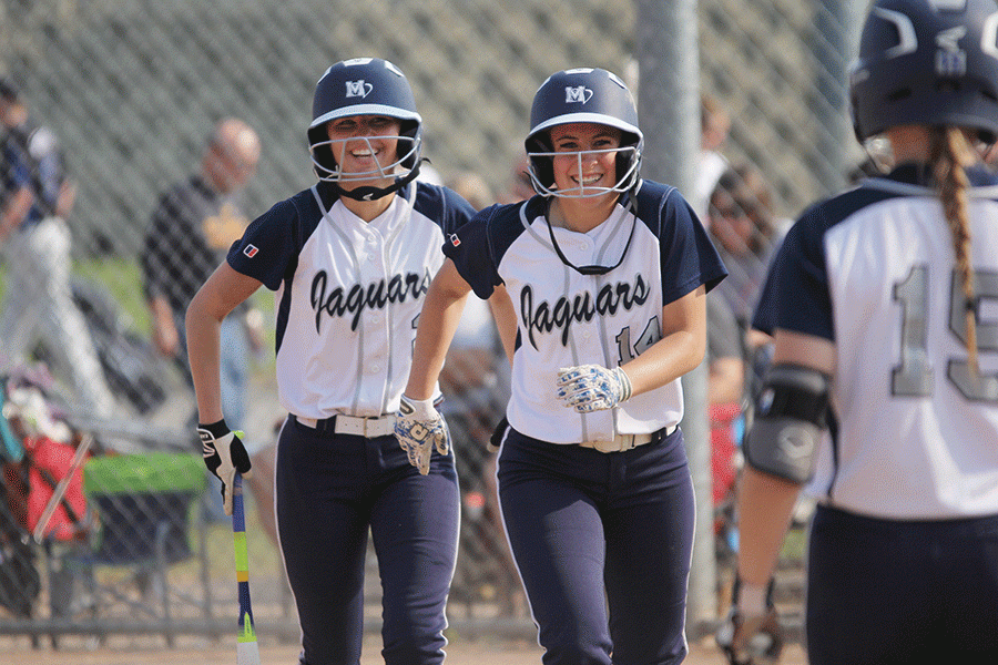 After scoring two runs, junior Lilly Blecha and sophomore Peyton Moeder run off the field celebrating. The Lady Jags beat Tonganoxie in a double header, 12-4 and 16-6.