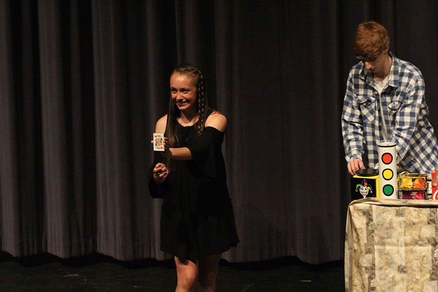 Freshman Delaney Kemp shows her card to the crowd during sophomore Jason Easleys magic performance. 