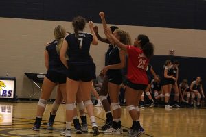 Varsity team members break a huddle after a score.