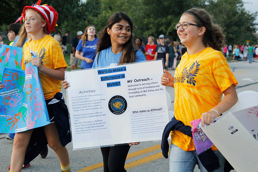 Freshman Anna Ricker, sophomore Fatima Hernandez and freshman Samantha Volkamer walk with MV Outreach during the parade.