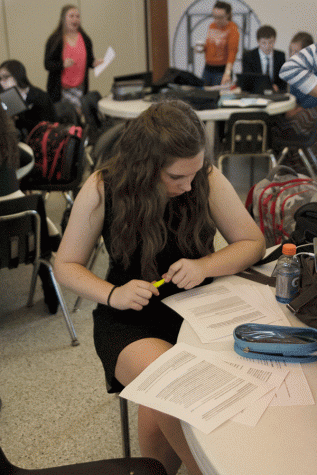 Senior Sydney Hall prepares for round one of the debate meet by reviewing her proposal and research.