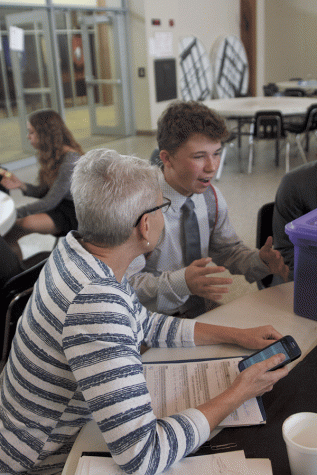 Debate sponsor Carmen Shelly discusses round one results with Sophomore Kaleb Shukeat.