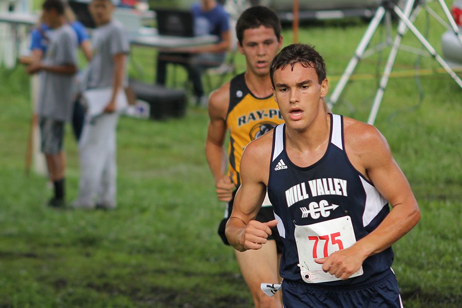 Junior Justin Grega passes an opponent while rounding a corner.