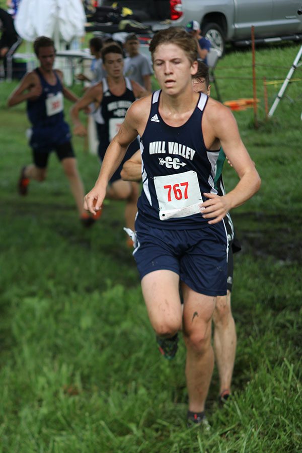 Junior Mitch Dervin keeps his pace while running through a mud puddle.