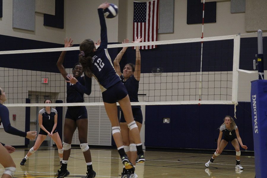 Junior Abigail Archibong and her teammate jump to block a spike from the Saints.