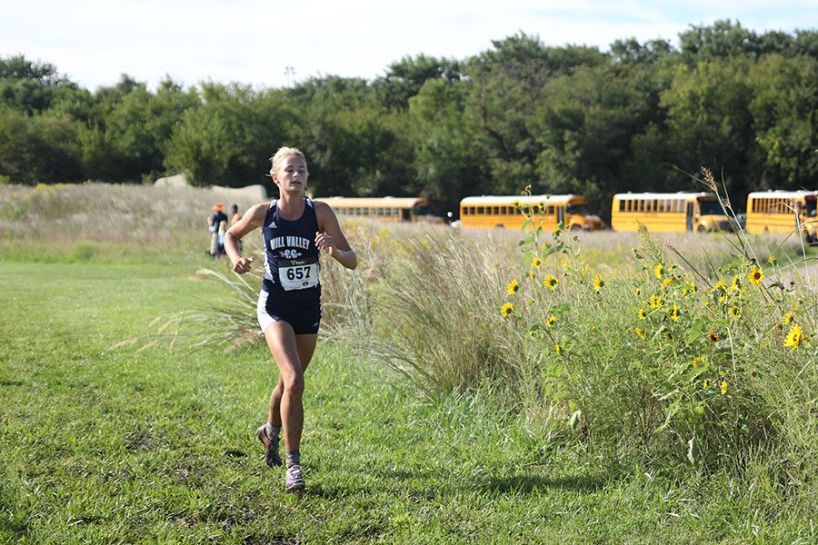 Junior Bella Hadden runs to the finish line to complete the race.