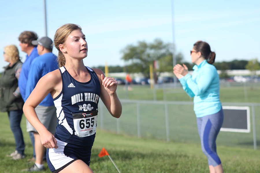 Junior Britton Nelson sprints ahead on Saturday, Sept. 10 at the Olathe North Long Elm Invitational cross country meet. As the muddy track provides a challenging course, the boys and girls varsity finishes strong with a first and sixth place.