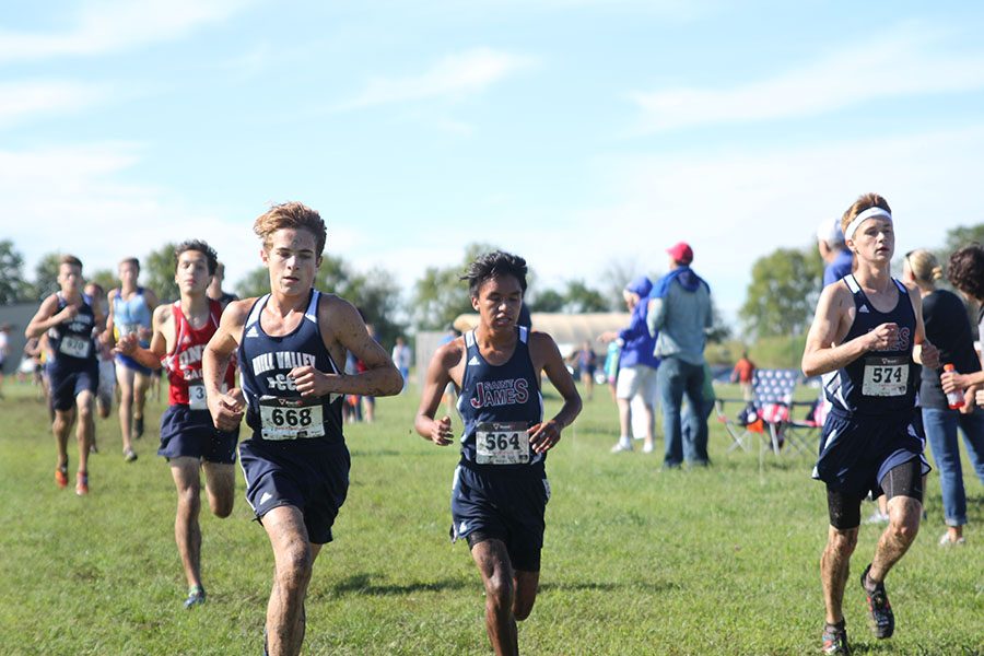 Freshman Nick Schmidt runs with opponents during the middle of the 5000 meter race.