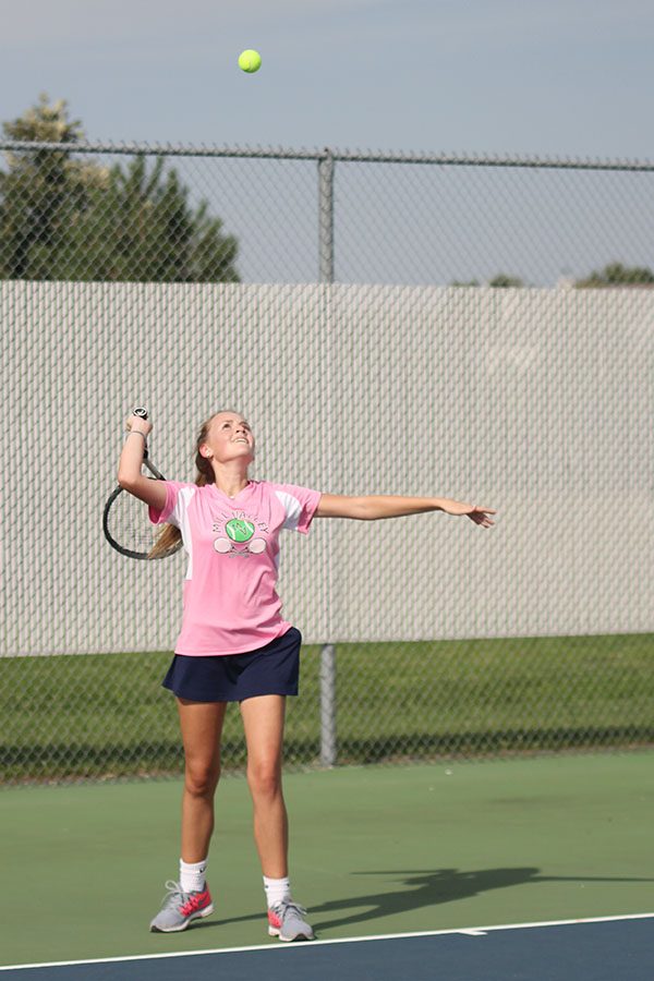 After serving, sophomore Emmerson Hall watches the ball in the air.