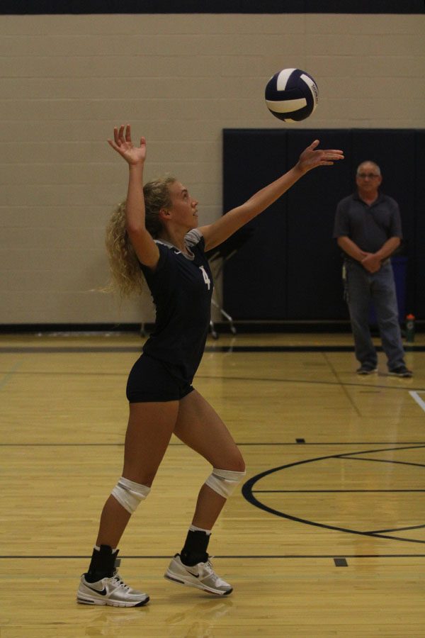 Senior Morgan Thomas steps forward to serve the ball to Blue Valley Southwest.