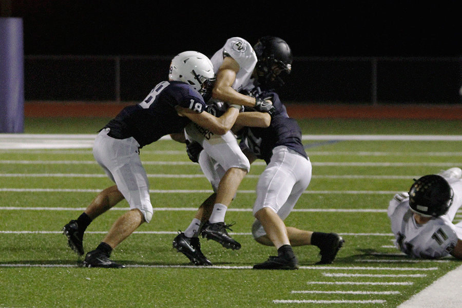 Junior wide receiver Evan Rice and senior defensive back Alec Bergeron tackle their opponent on the field.