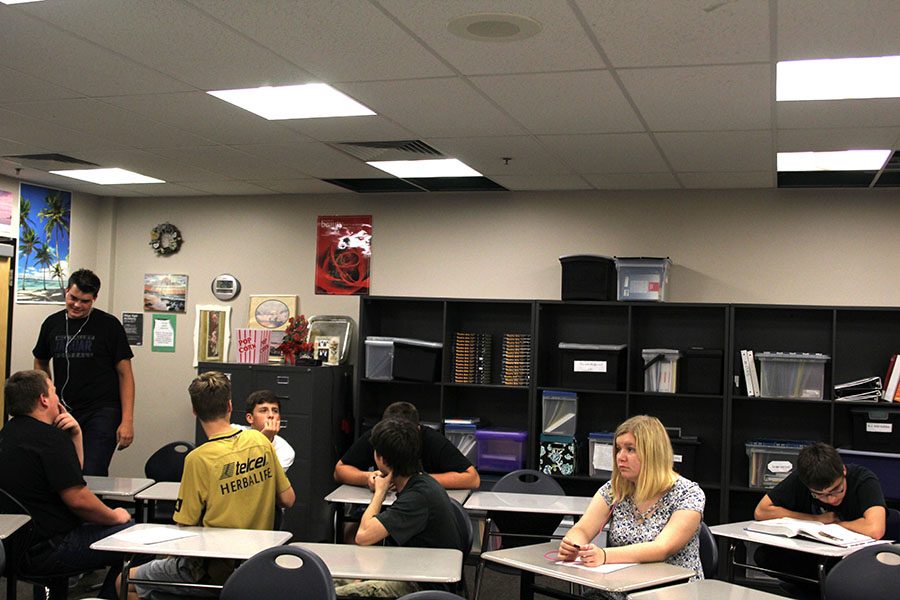 Students in Jeannette Hardestys class look up at the holes in her room, but continue normal seminar activities despite the damage in the ceiling. 