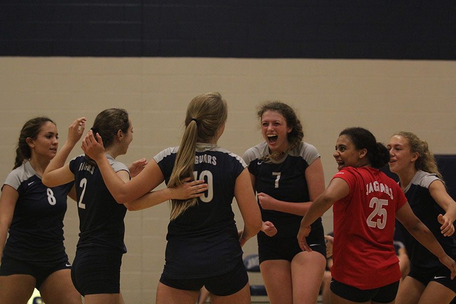 Celebrating after a scored point, senior Maggie Bogart cheers with fellow teammates. 