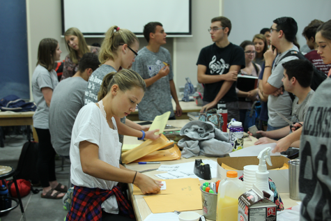 Junior Jordan Robinson works on placing t-shirt designs into the folders.