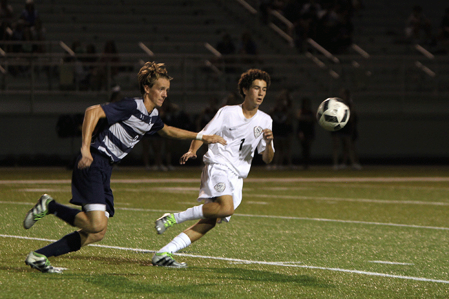 Senior Spencer Butterfield sticks out his arm as he races his St. James opponent to the ball on Tuesday, Sept. 6.