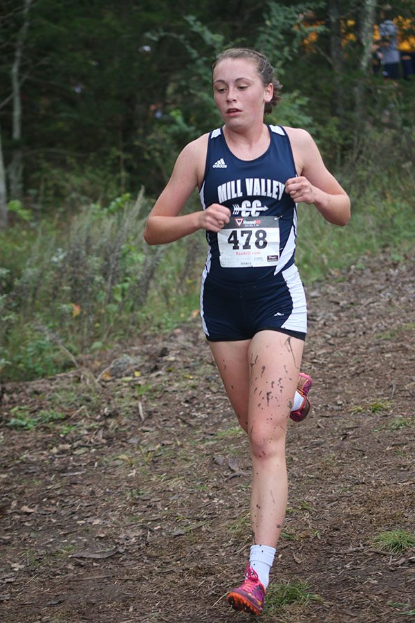 Sophomore Delaney Kemp keeps her pace while covered in mud. She placed 31st among 63 other runners.