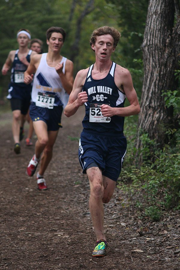 Rounding a curve, senior Jakob Coacher leads a group of runners. He finished the race in 11th place.