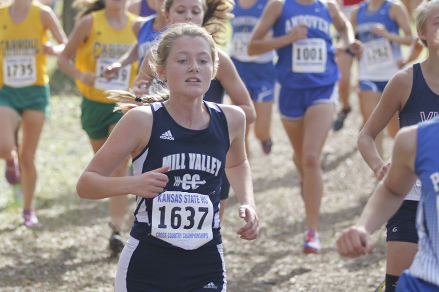 Freshman Jenna Walker runs alongside her competitors before placing 45th.