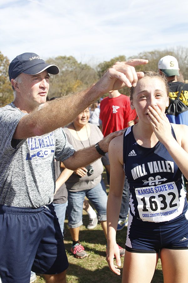 Coach Mark Chipman explains the standings of the  girls team to Kemp.