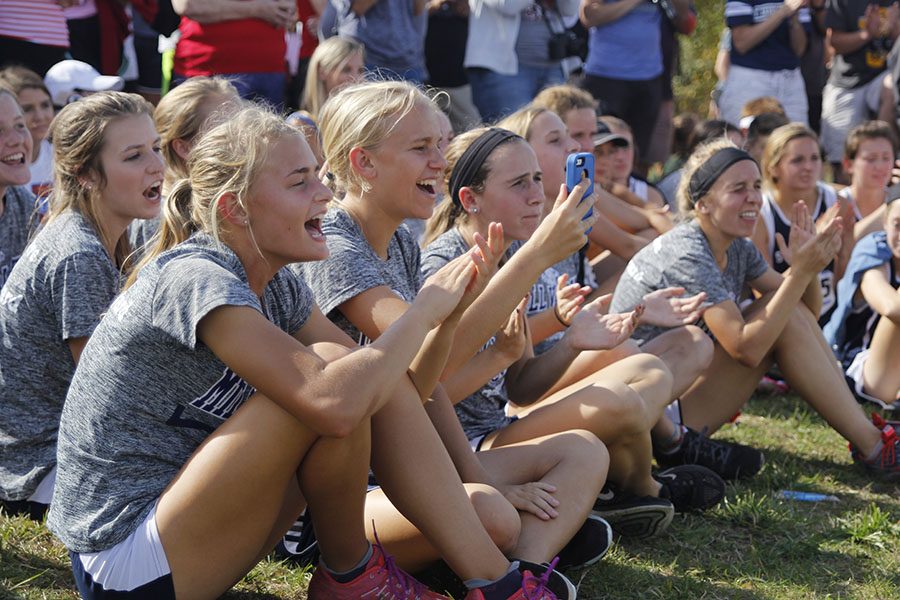 The girls cross country team cheers as Nelson is announced the third place runner during the awards ceremony.