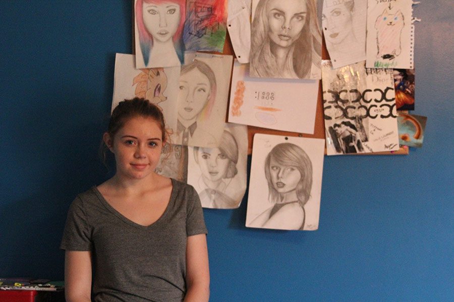 Standing beside her artwork, freshman Shaina Isaacsen poses on Saturday, Oct. 30.  Drawing and painting gives me a feeling of pride knowing how hard Ive worked and seeing how far Ive came since the beginning, Isaacsen said.