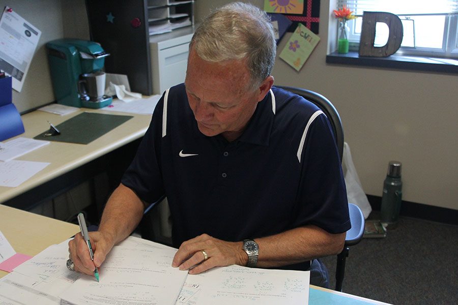 Retired math teacher John McFall grades papers for Jessica DeWilds College Algebra class.