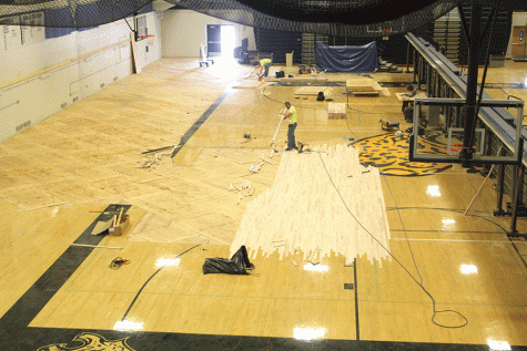 An ACE worker places wood on the gym floor on Monday, Oct. 10. The project is expected to be completed by Monday, Nov. 14.