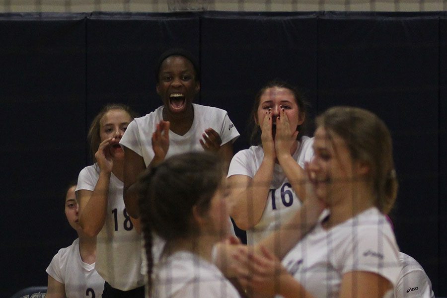 Junior Abby Archibong cheers with her teammates from the sidelines after a tense volley.
