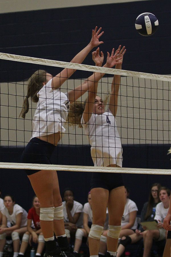 Senior Morgan Thomas and her teammate reach for the ball.