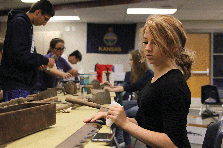 Junior Chandler Randolph cleans an antique two-handle saw in Archaeology class on Tuesday, Oct. 4.