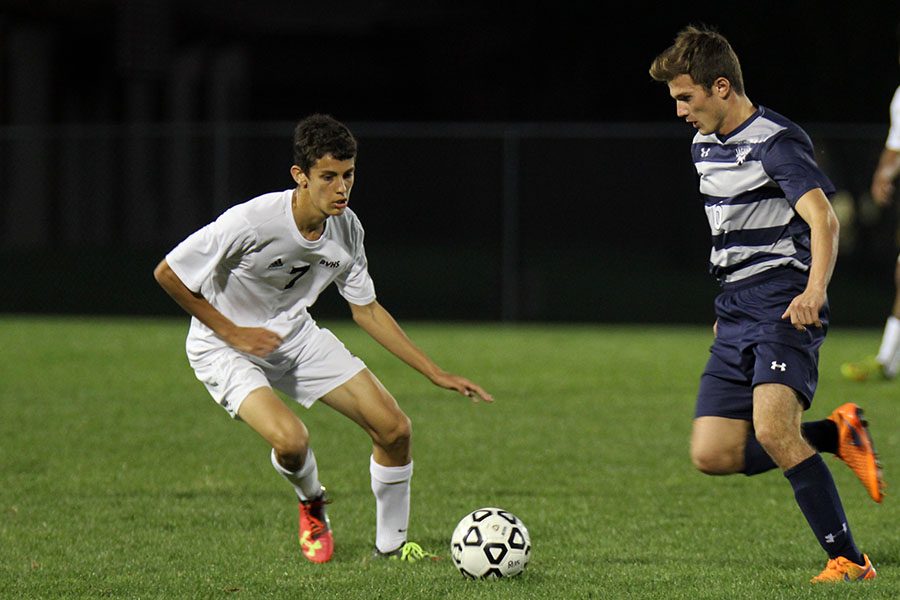 Running towards the ball, senior Sam Lopez attempts to win possession.