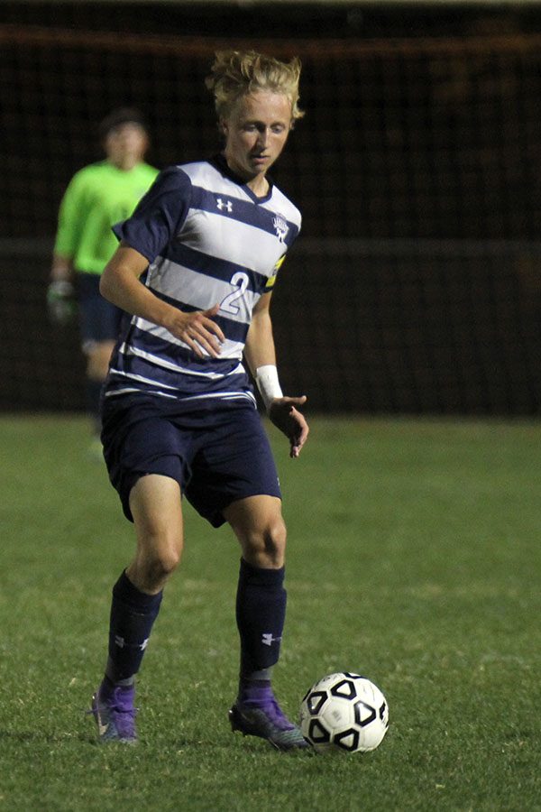 Focusing on the ball, senior Noah Veal looks for an open teammate. 