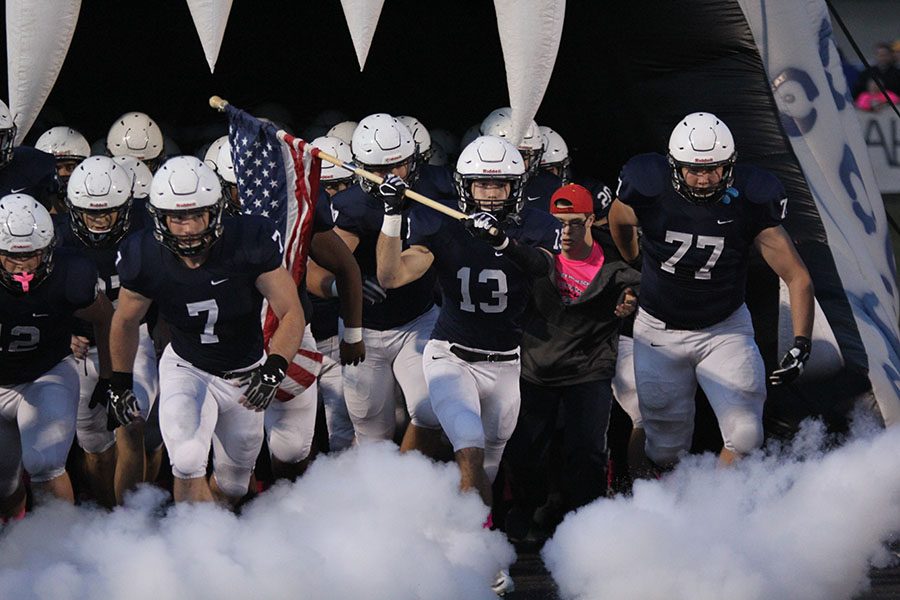On Friday, Oct. 14 the Jaguars lose to Blue Valley North 23-52. While carrying the American flag, senior Joel Donn runs out onto the field. 