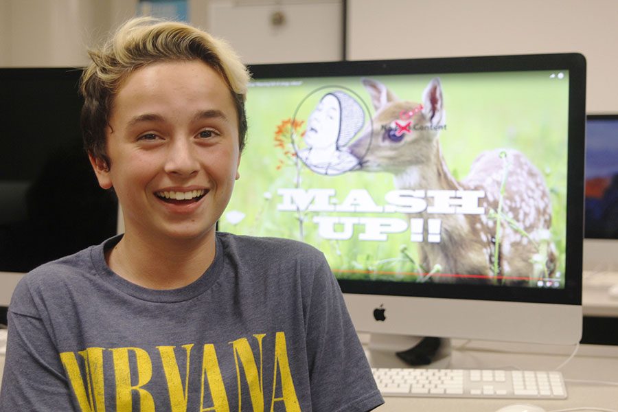 With a video from his YouTube channel pulled up in the background on Tuesday, Oct. 18, freshman Aidan Thomas smiles in journalism teacher Dorothy Swaffords classroom. I like [YouTube] because I can share my videos, Thomas said. Even if nobody watches them, I can still post them and I feel good that some people will [get to] experience my content.