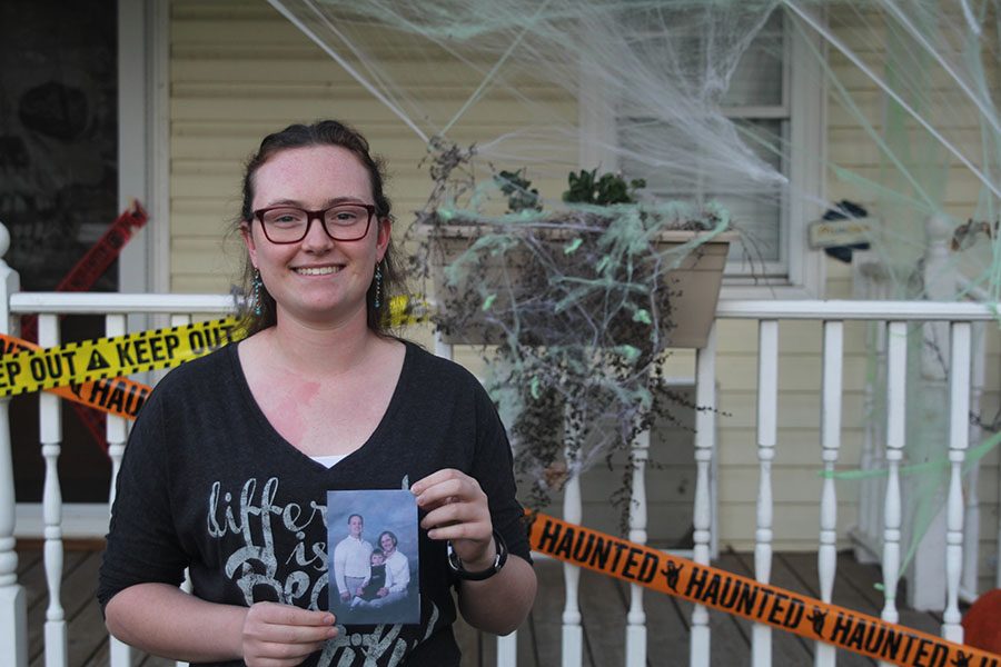Standing outside her moms house, sophomore Rachel Kurovski holds a picture of her, her mother, and her father on Monday, Oct. 24. I try to be nice to people because I don’t want them [to] deal with what I do with my dad [when] he’s not nice to people, Kurovski said. I don’t want other people [to] feel like that.