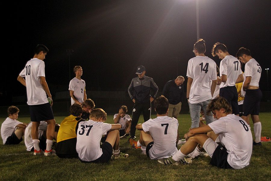 Upset with their loss, the team sits together to reflect the game.