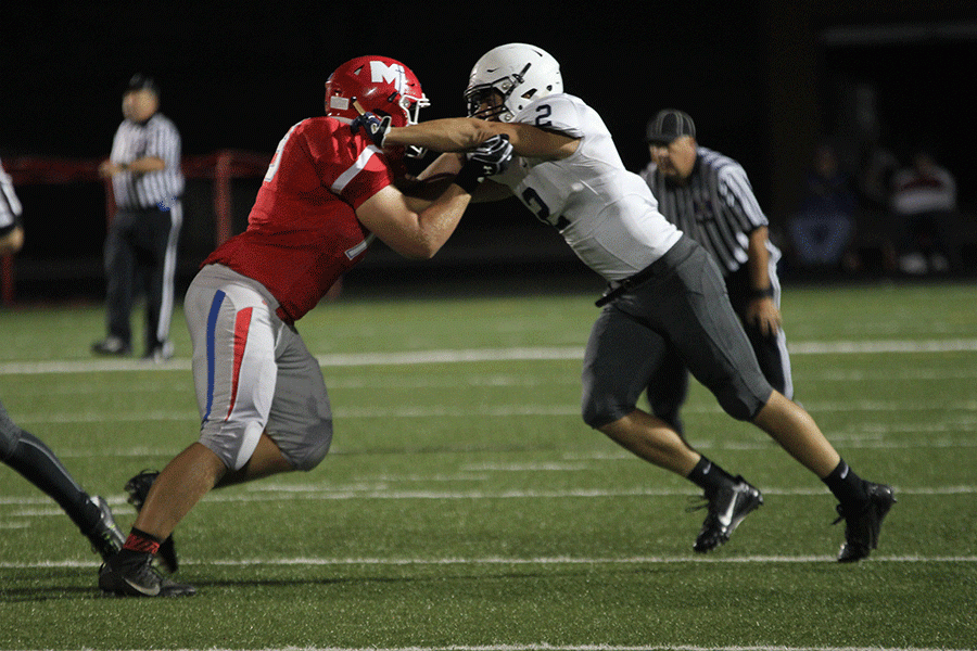 On Friday, Oct. 7 the Jaguars fall to Bishop Miege 21-64. Arms extended, junior Ike Valencia blocks his opponent.